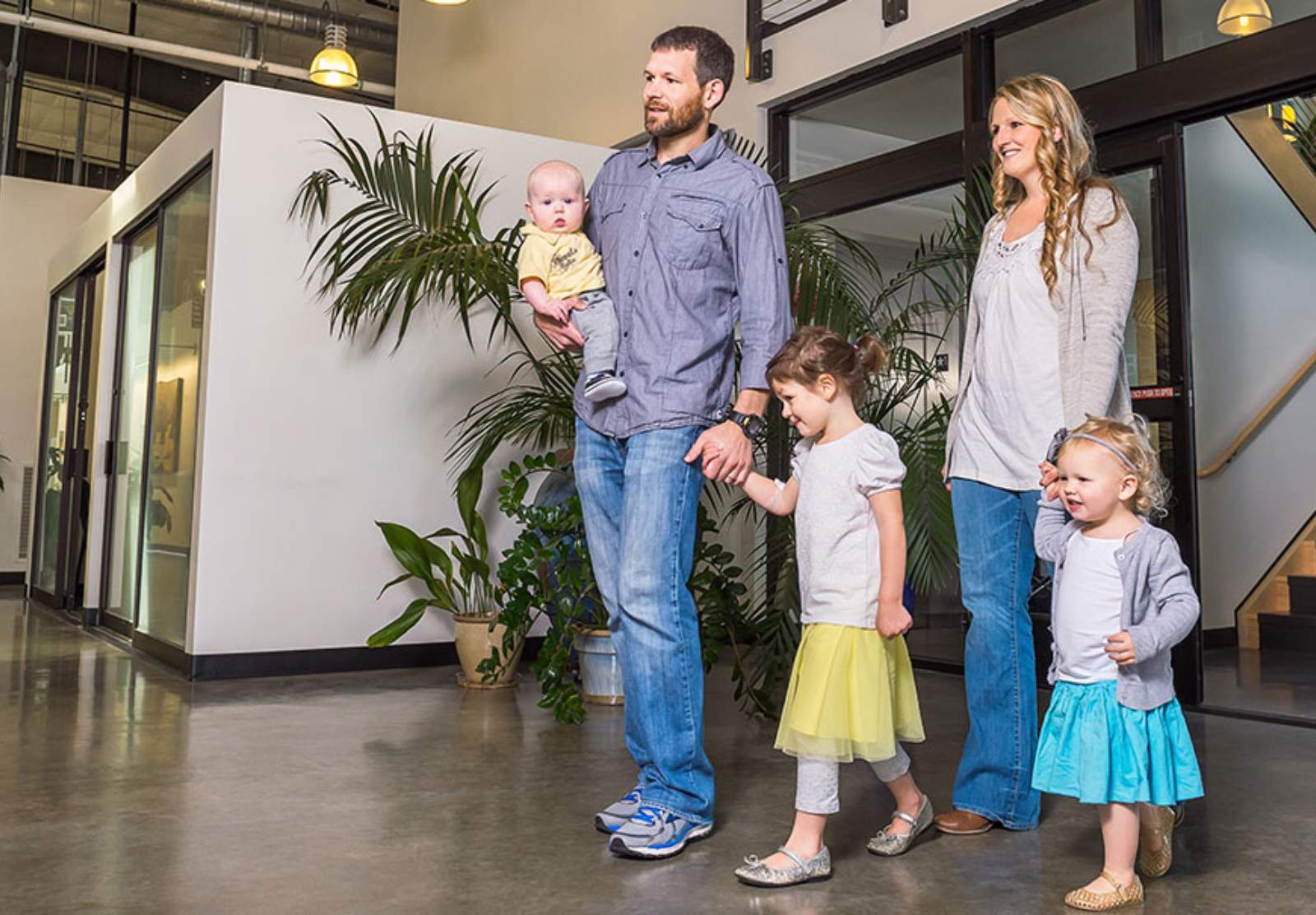 Two parents and three young children in the lobby of a medical building